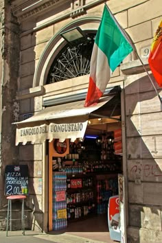 an italian flag hanging from the side of a building in front of a bicycle shop