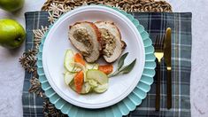 a white plate topped with meat and veggies on top of a blue place mat