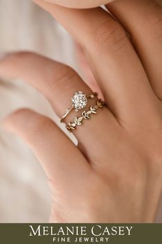 a woman's hand with a gold ring and two diamond rings on her fingers