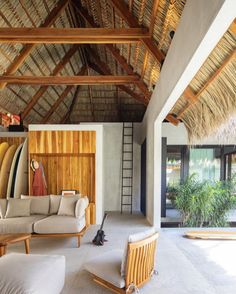 a living room filled with furniture under a thatched roof