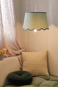 a lamp hanging over a bed next to a window