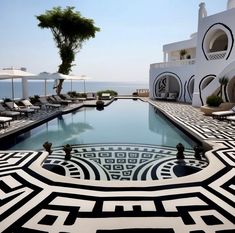 an outdoor swimming pool with lounge chairs and umbrellas