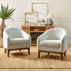 two white chairs sitting next to each other in a living room