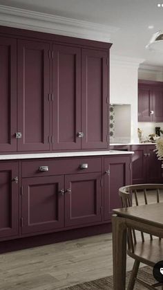 a dining room table and chairs with purple cabinets in the back drop off area on the wall