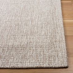 a close up view of a rug on the floor with wood floors in the background