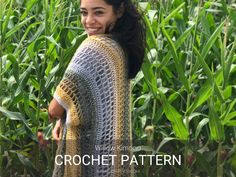 a woman in a crochet shawl smiles while standing in a cornfield