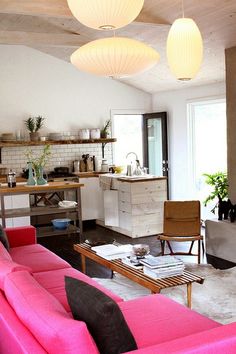 a living room filled with furniture and lots of lights hanging from the ceiling above it