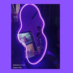 a man standing in front of a mirror with a purple light on it's face