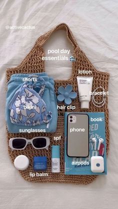 the contents of a purse laid out on top of a bed, including sunglasses and other items