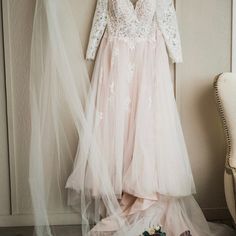 a wedding dress hanging on a wall next to a pair of shoes and a veil