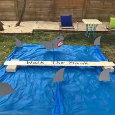 a blue tarp with shark fin design on it and some chairs in the background