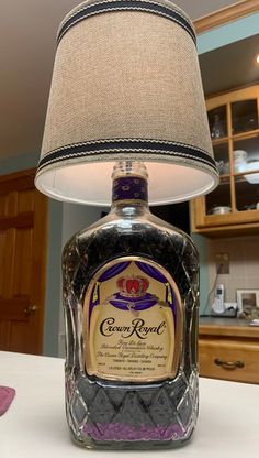 a lamp that is sitting on top of a table next to a bottle of liquor