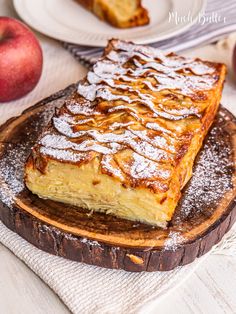 two pieces of french toast sitting on top of a wooden cutting board next to an apple