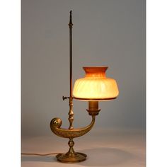 an old fashioned lamp with a glass shade on it