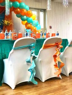 the chairs are decorated with orange, blue and green ribbons on each chair's back