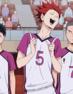 three young men standing next to each other in front of an audience at a basketball game