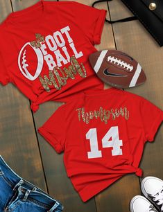 two shirts that say football mom and daughter on the front, one is red with gold glitter