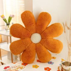 an orange flower shaped stuffed animal sitting on top of a table