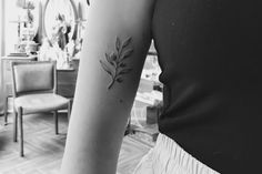 a black and white photo of a woman's arm with a flower tattoo on it