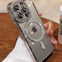 a person holding up an iphone case with some jewels on it and a starbucks cup in the background