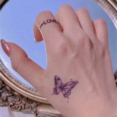 a woman's hand with a butterfly tattoo on it