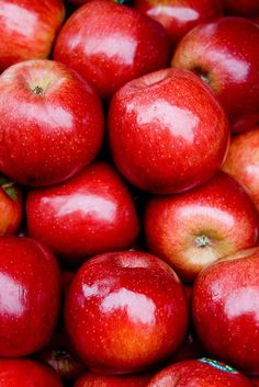 a pile of red apples sitting next to each other