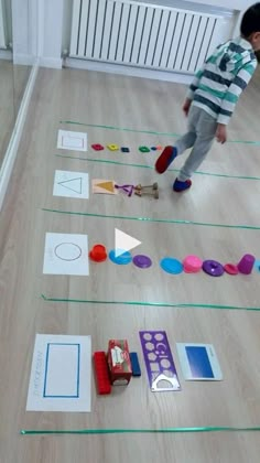 a young boy is playing with toys on the floor