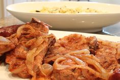 some food is on a white plate and next to a bowl of rice with meat