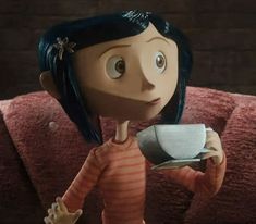 an animated doll holding a coffee cup and saucer in her hand while standing on a couch