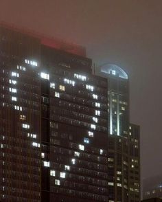 the building is lit up at night with many windows and lights on it's sides