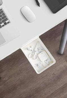 a white desk with an open laptop and various office supplies