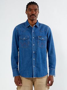 The Wrangler x PacSun Western Denim Long Sleeve Shirt combines rugged style with classic detailing. Featuring a dark indigo wash, a classic single button collar, western stitch details throughout, snap-flap chest pockets, a snap front closure, and a slightly frayed hem, it’s finished with a Wrangler x PacSun woven label at the flap pocket for an authentic touch. Denim Long Sleeve Shirt, Pacsun Mens, Denim Shirt Men, Long Sleeve Denim Shirt, Wrangler Shirts, Rugged Style, Dark Indigo, Woven Label, Mens Denim