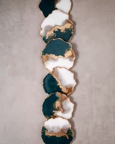 three green and white plates sitting on top of each other in front of a wall