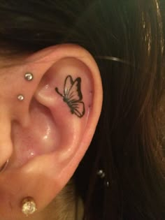 a woman with a butterfly tattoo on her left ear