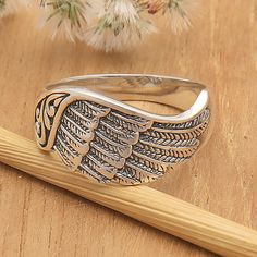 With its unique wing theme, a traditional Balinese motif with openwork accents as well as a perfect blend of oxidized and polished finishes, this band ring is a fashionable accessory that complements any look with style. Presented by Komang Wijayana, this design is meant for those who love avant-garde jewelry that breaks the mold. Engraved Winged Sterling Silver Jewelry, Sterling Silver Winged Rings In Silver, Engraved Wing-shaped Silver Jewelry, Spiritual Winged Sterling Silver Jewelry, Elegant Wing-shaped Silver Jewelry, Avant Garde Jewelry, Sterling Silver Rings Bands, Sterling Silver Cuff Bracelet, Silver Band Ring