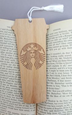 an open book with the starbucks logo on it and a string hanging from it's cover