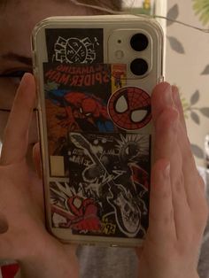 a person holding up a cell phone case with stickers on the back of it