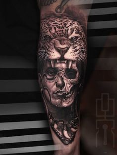 a man's arm with a black and white tattoo design on it, featuring a leopard