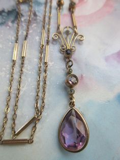 Older vintage lavaliere necklace in gold fill. I would date this pretty gold fill necklace at least back to 1930. It wears in elegant Edwardian style. It is crafted with a combination of lovely old links that create a length of 16.5'' with a drop of 1 -7/8''. It's faceted amethyst colored glass pendant is in a tear drop shape and measures .5'' x 3/8''. It suspends from a fancy bail . This estate necklace will wear beautifully as a layering necklace to compliment your Edwardian to Deco styles and Edwardian Style, Amethyst Color, Edwardian Fashion, Layering Necklace, Tear Drop, Glass Pendant, Glass Pendants, Layered Necklaces, Colored Glass