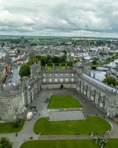 an aerial view of a large castle with lots of green grass