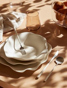 the table is set with white dishes and silverware