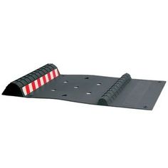 a black ramp with red and white stripes on the side, attached to a wall