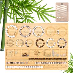 a bamboo board with several different types of beads and bracelets on it next to a palm tree