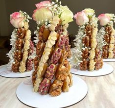 there are four flower vases made out of pretzels and nuts on the table