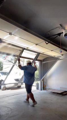 a man is walking in an empty garage