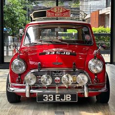 an old red car with a surfboard on top of it's headlight