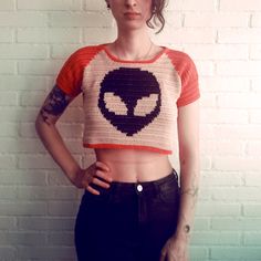 THIS IS A CROCHET PATTERN, NOT A FINISHED PRODUCT Immediately after purchasing, you will receive a downloadable PDF copy of this pattern. You can access this link at any time. Please reach out to me if you need anything! This top is made with a basic stitch using the tapestry crochet technique. I made an alien but in this pattern I will explain how you can use any image for your project if you have access to Photoshop! It's quite easy but in case you're not able to use it I will include different alien sizes on this PDF file that you can print to make the grid! The Street Kid Top can be made in any size using any kind of yarn and hook! Since I will be explaining how to make it using measurements instead of standard sizes, I will use my measurements as a reference throughout this pattern. I Crochet Crop T Shirt, Crochet Shirts Patterns, Glow In The Dark Yarn Crochet Patterns, Cute Crochet Tops Summer Outfits, Fast Crochet Projects Free, Halloween Crochet Top, Witchy Crochet Patterns, Crochet Tee Pattern, Edgy Crochet