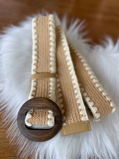 Fall for this superb golden beige braided straw effect elastic belt decorated with embroidery and round wooden buckle. It adapts to all sizes for an original look. Wear over a tunic, a dress, loose pants for a timeless vintage and boho style. Perfect to give as a gift or to treat yourself! Length 107cm Width 4.5cm Buckle diameter 7.5cm Chic Woven Belts For The Beach, Chic Woven Belts For Beach, Chic Woven Belt For Beach, Beige Woven Belt For Vacation, Beige Woven Belts For Spring, Spring Beige Woven Belt, Casual Brown Woven Belt, Spring Beige Rope Belt, Chic Brown Belt For The Beach