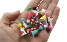 a hand holding several small colorful objects in it's palm with polka dots on them