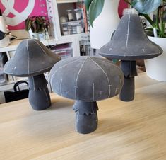 two gray mushrooms sitting on top of a wooden table